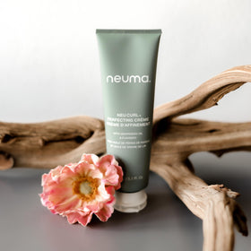 NEUMA styled model outdoors with defined curls showing UV protection and shine