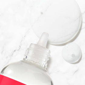 Neutrogena bottle in hand dispensing drop, easy application benefit