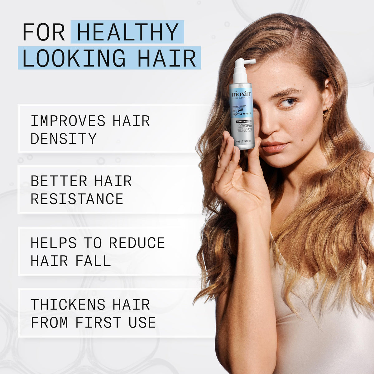 NIOXIN applying serum to scalp, demonstrating targeted application for stronger roots