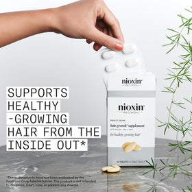 NIOXIN open bottle with tablets spilling, illustrating daily-dose accessibility and routine use