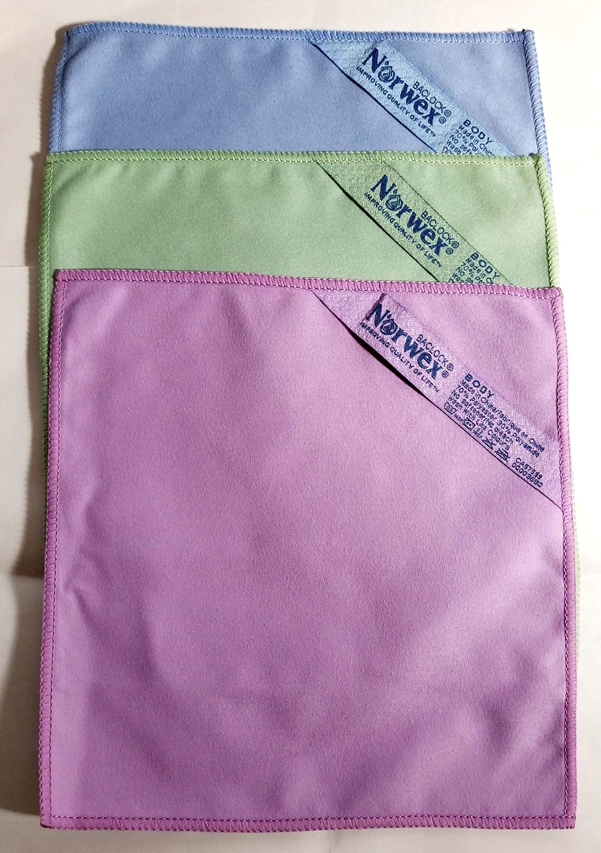 Norwex suede face cloth front view showing three colors and gentle texture benefit
