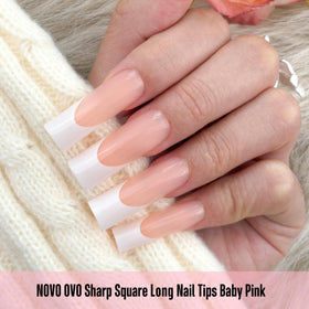 NOVO OVO hand holding a tip for scale to show length options and fit for varied nail beds