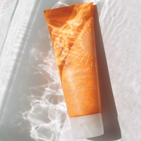 Nu Skin Sunright bottle beside sunglasses suggesting travel convenience