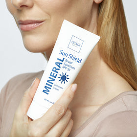 Obagi Sun Shield Mineral next to common objects showing compact 3 oz size