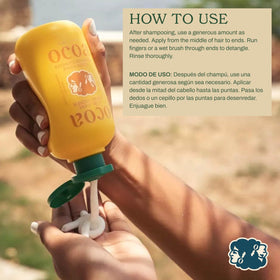 OCOA conditioner in hand being applied to hair demonstrating easy distribution and slip