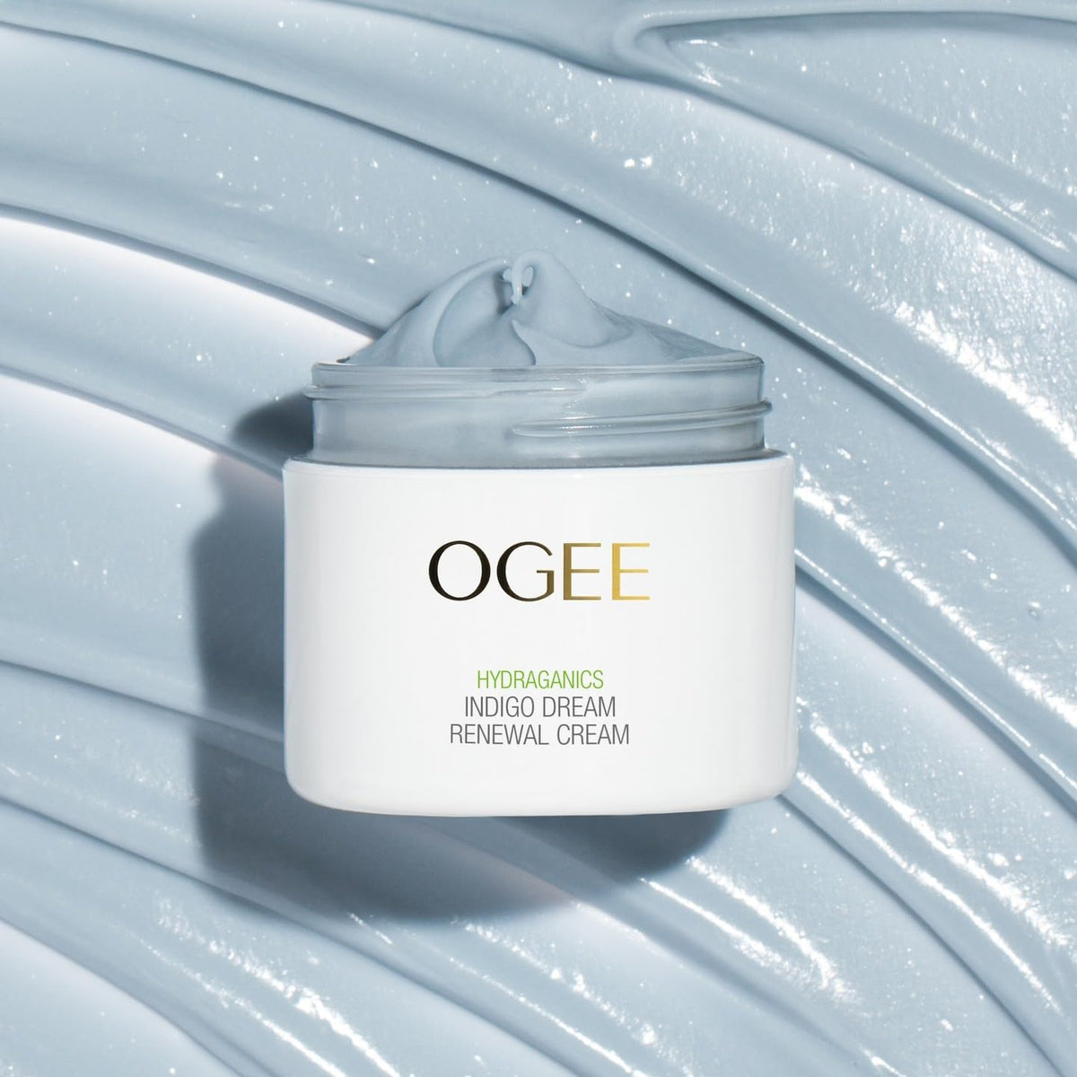 Ogee cream beside flowers illustrating botanical formulation and soothing benefit
