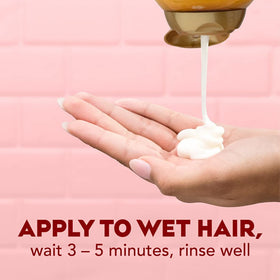 OGX conditioner pouring into hand to show consistency and easy application benefit