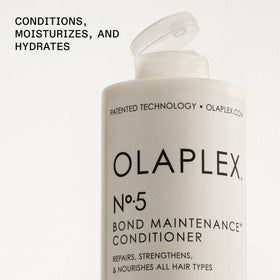 Applying Olaplex Nº.5 to mid-lengths demonstrating easier detangling benefit