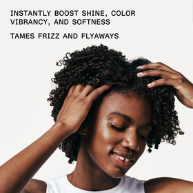 Applying Olaplex No.7 to damp hair mid-lengths demonstrating heat-protection preparation