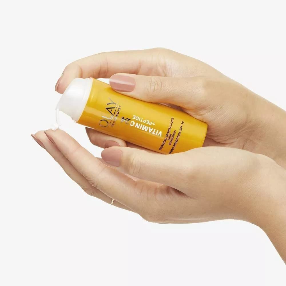Olay morning routine lifestyle shot applying moisturizer for bright protected skin