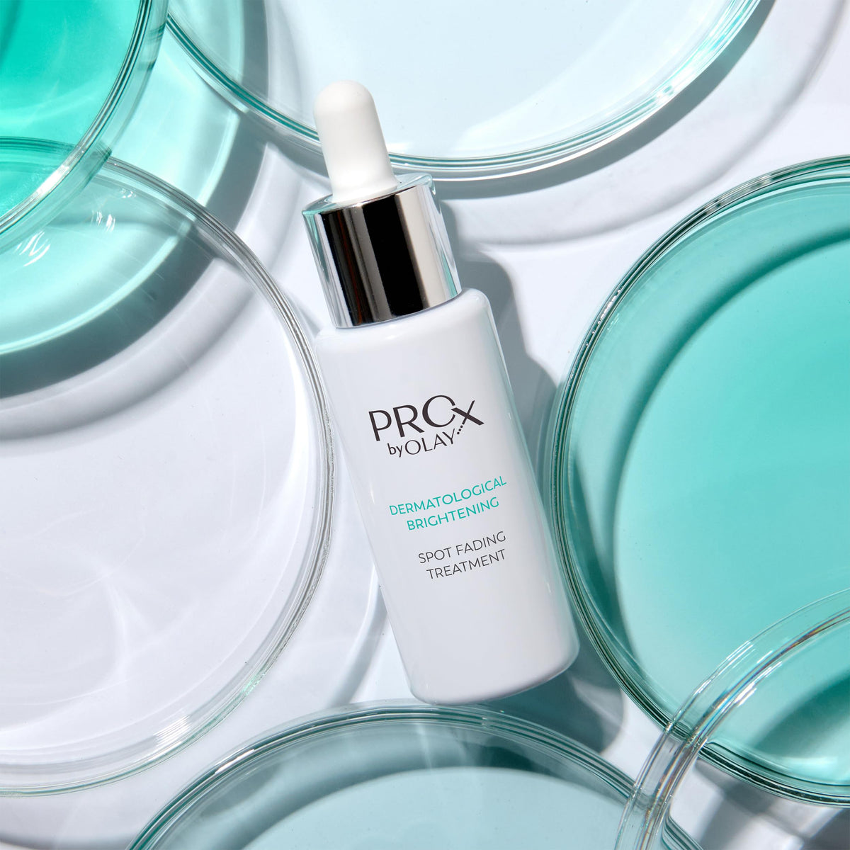 Olay Pro-X lifestyle image of woman applying serum to face for brighter tone
