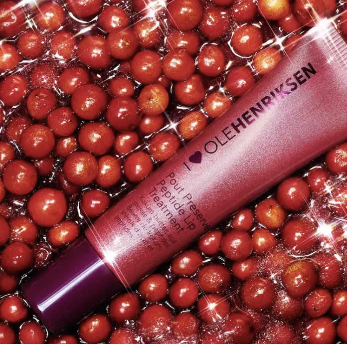 Ole Henriksen lifestyle shot applying Pout Preserve to lips demonstrating hydrating shine and buildable color