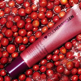 Ole Henriksen lifestyle shot applying Pout Preserve to lips demonstrating hydrating shine and buildable color