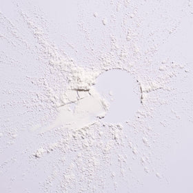 ORIBE powder being applied to roots, demonstrating quick oil-absorbing refresh benefit