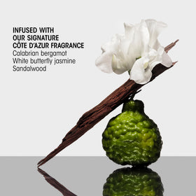 Oribe Balm D'Or applied to damp hair in hand demonstrating easy distribution