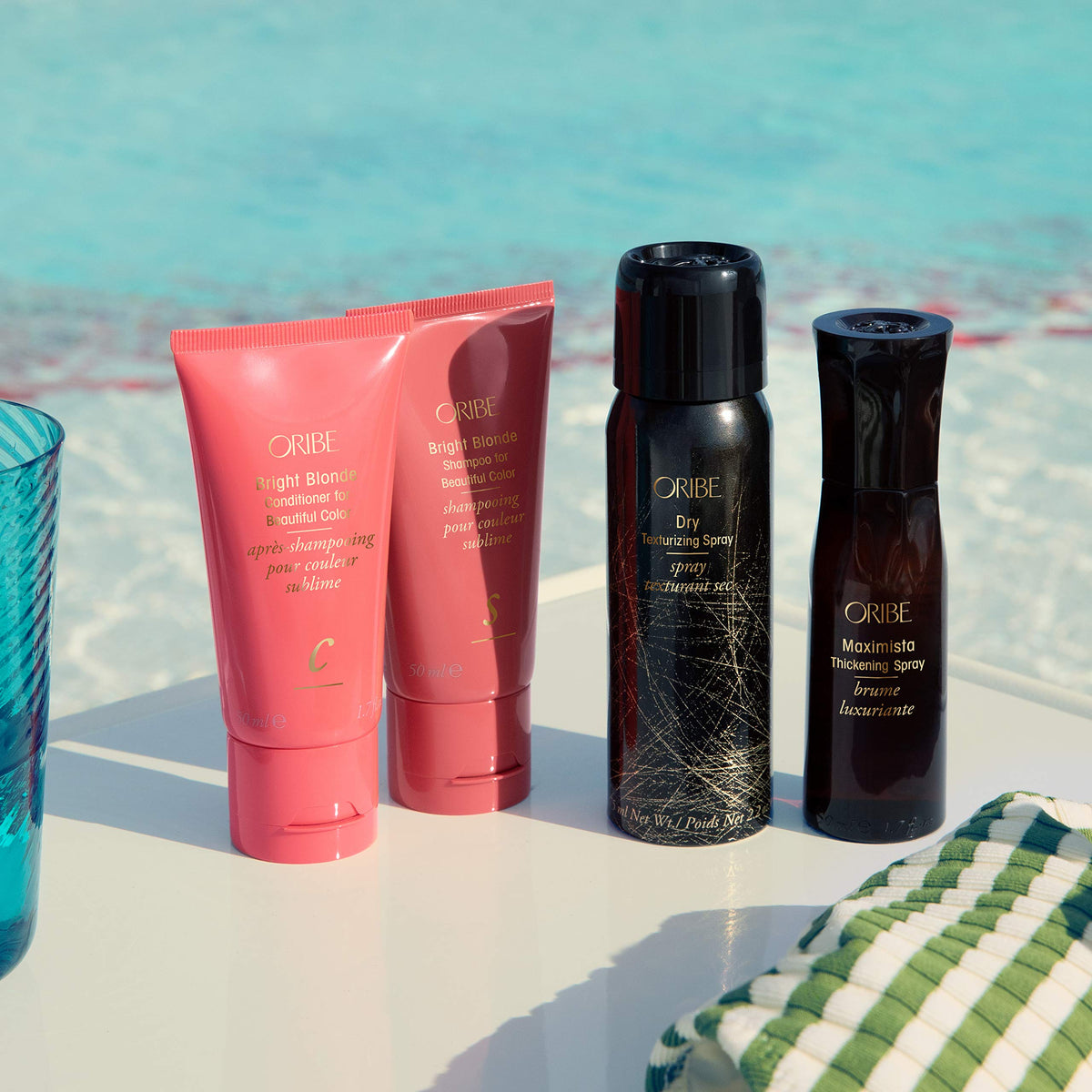 Hand applying Oribe conditioner to damp blonde hair for detangling benefit