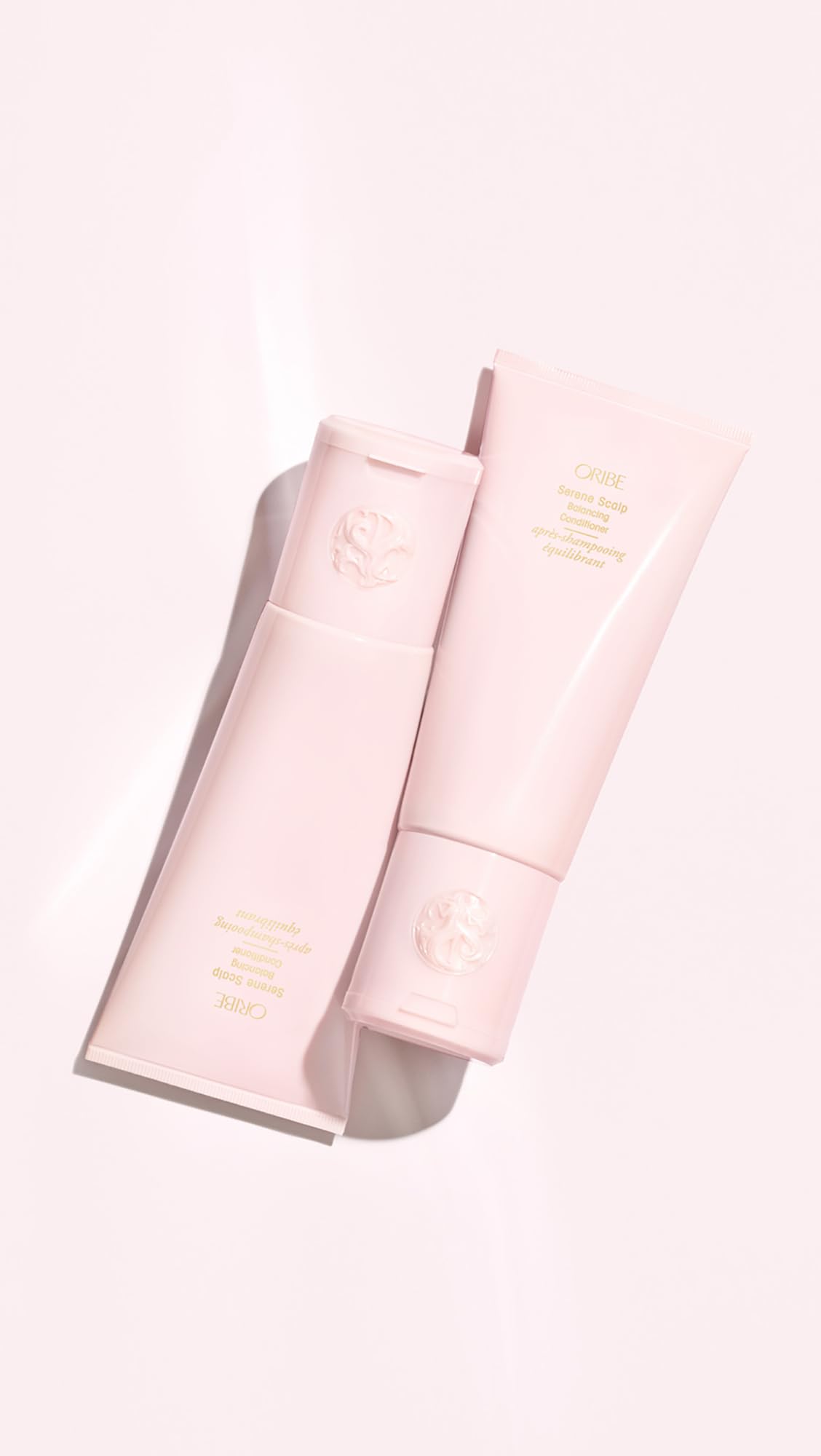 Applying Oribe conditioner in hand to show targeted scalp hydration benefit