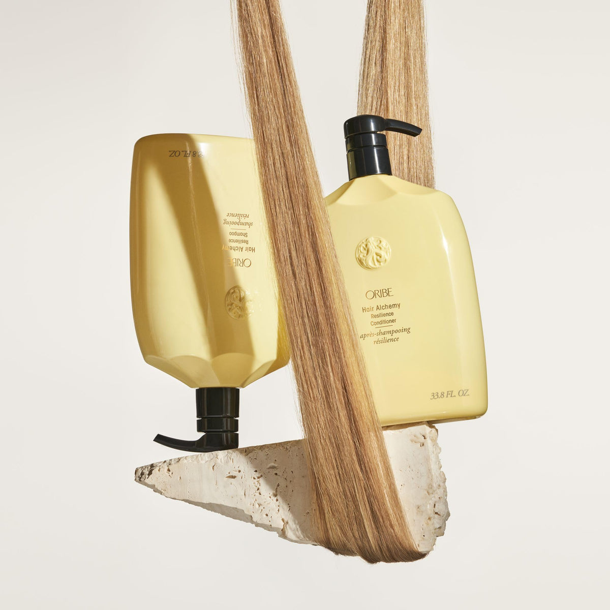 Oribe conditioner in shower being applied to damp hair showing detangling benefit