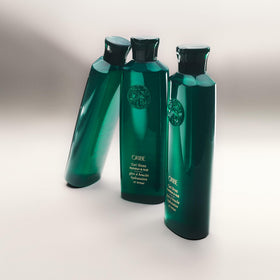 ORIBE product being diffused on curly hair showing enhanced definition