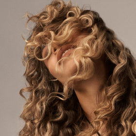 ORIBE applied to curly hair during wash to detangle and soften