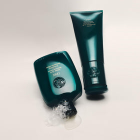 Oribe eternal curls shampoo 8.5oz next to common bottle to show compact travel size