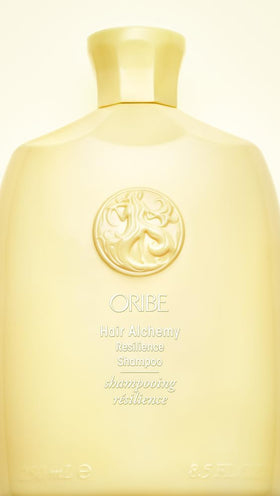 Oribe Hair Alchemy bottle in hand to show 8.5 fl. oz. scale and ease
