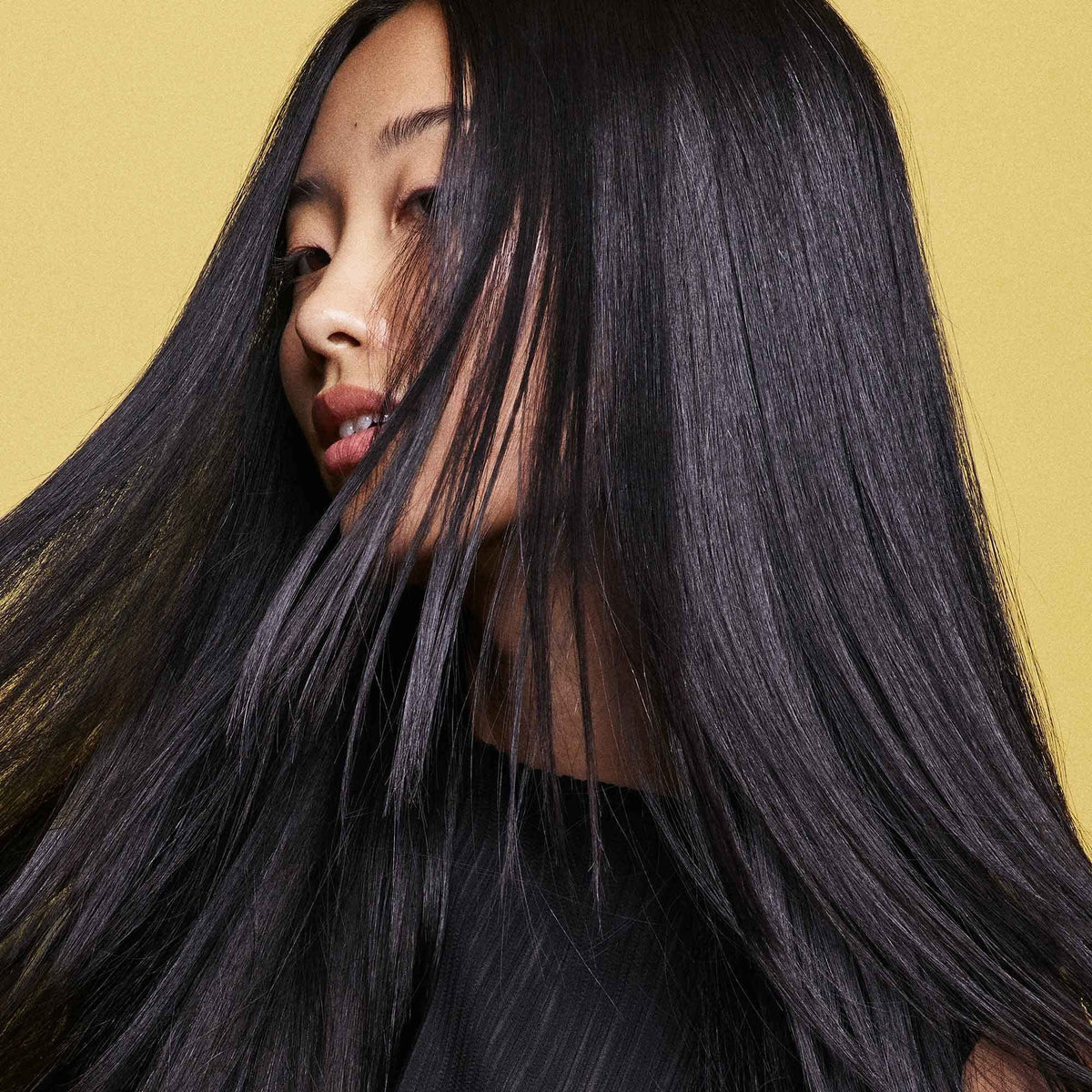 Oribe conditioner in hand to show 1.7 oz travel size and portability benefit