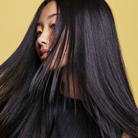 Oribe conditioner in hand to show 1.7 oz travel size and portability benefit