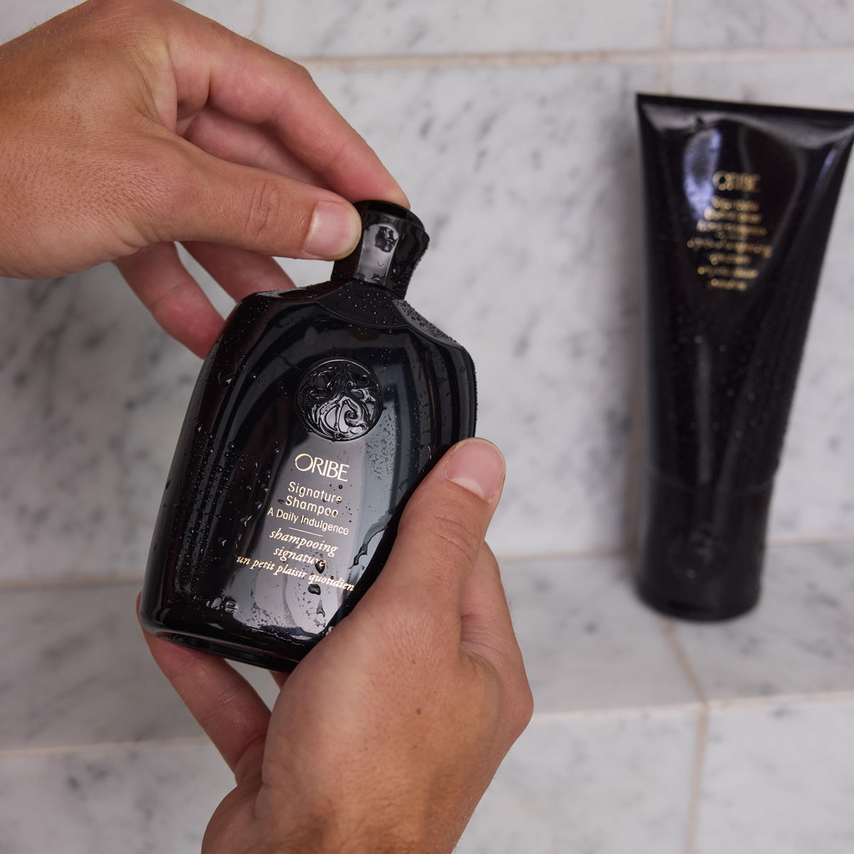 Oribe signature conditioner salon bottle on shelf illustrating professional use-ready