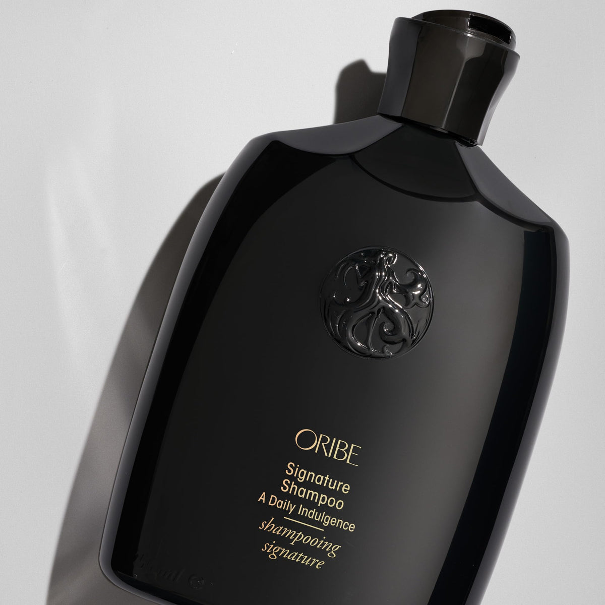 Oribe Signature Shampoo paired with conditioner in lifestyle setting showing brand styling benefit