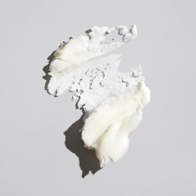 ORIBE paste texture close-up on finger demonstrating creamy consistency and easy spreadability