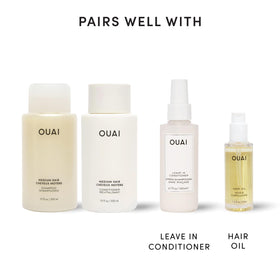OUAI bottles in hand to show 10 fl oz size and travel-friendly benefit