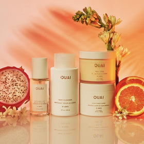OUAI gift set inside a beach bag evoking vacation-ready fragrance