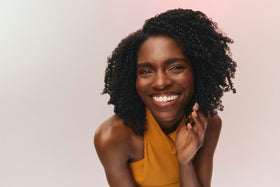 Close-up of black castor oil and botanicals highlighting Ouidad strengthening benefit
