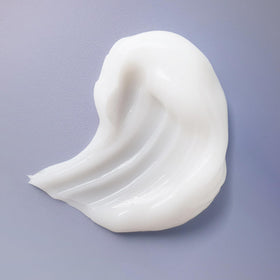 Ouidad cream applied to wet curls demonstrating even distribution and frizz control