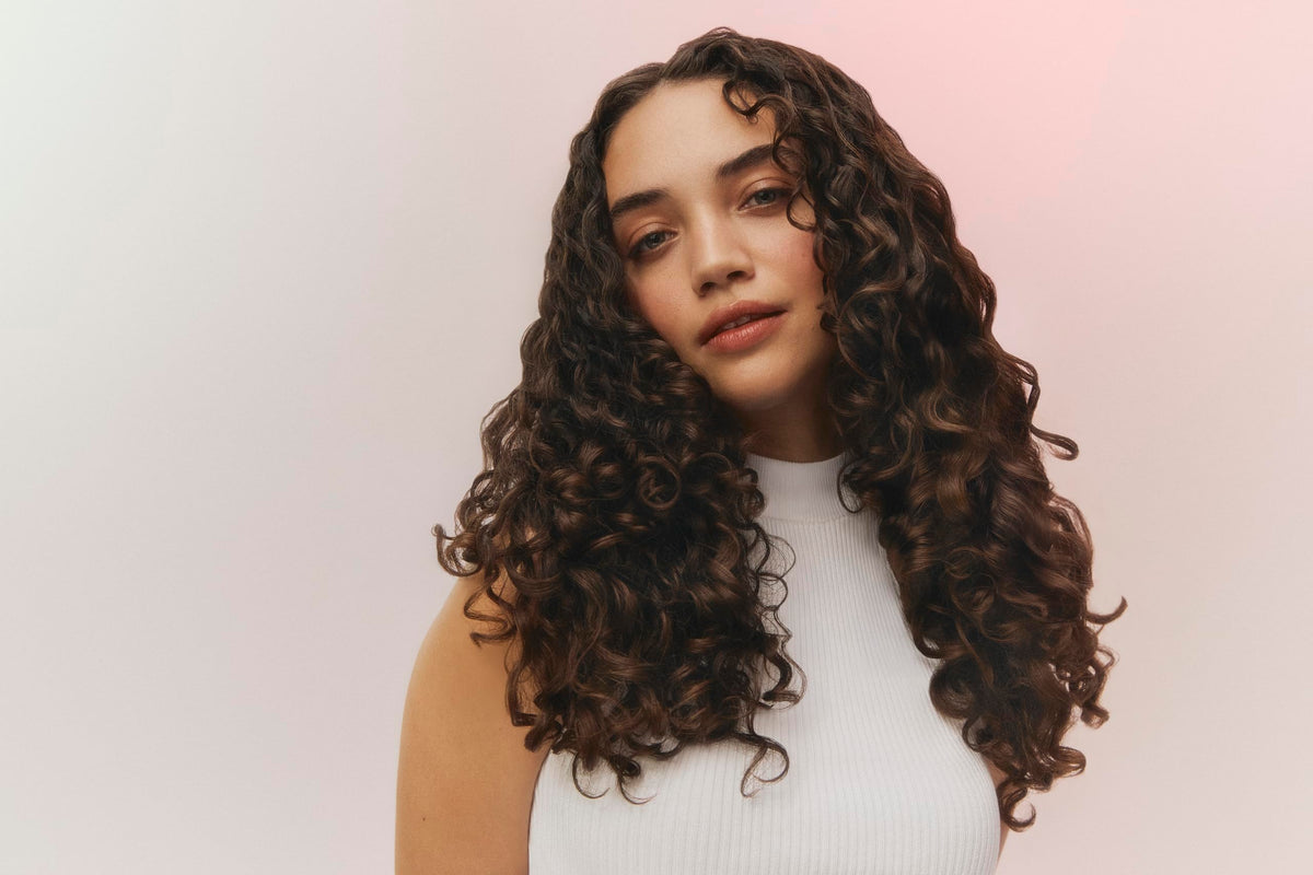 Ouidad VitalCurl serum on hand demonstrating lightweight, non-greasy texture