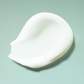 Close-up foam texture from Ouidad shampoo showing lightweight, non-stripping lather