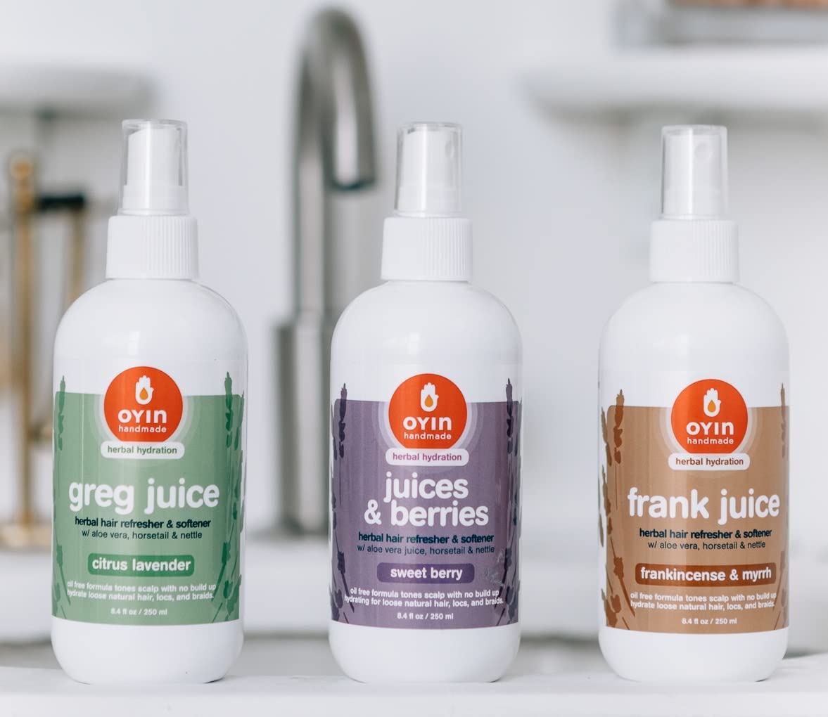 Oyin Handmade Greg Juice mist being sprayed on curls to hydrate and refresh styles