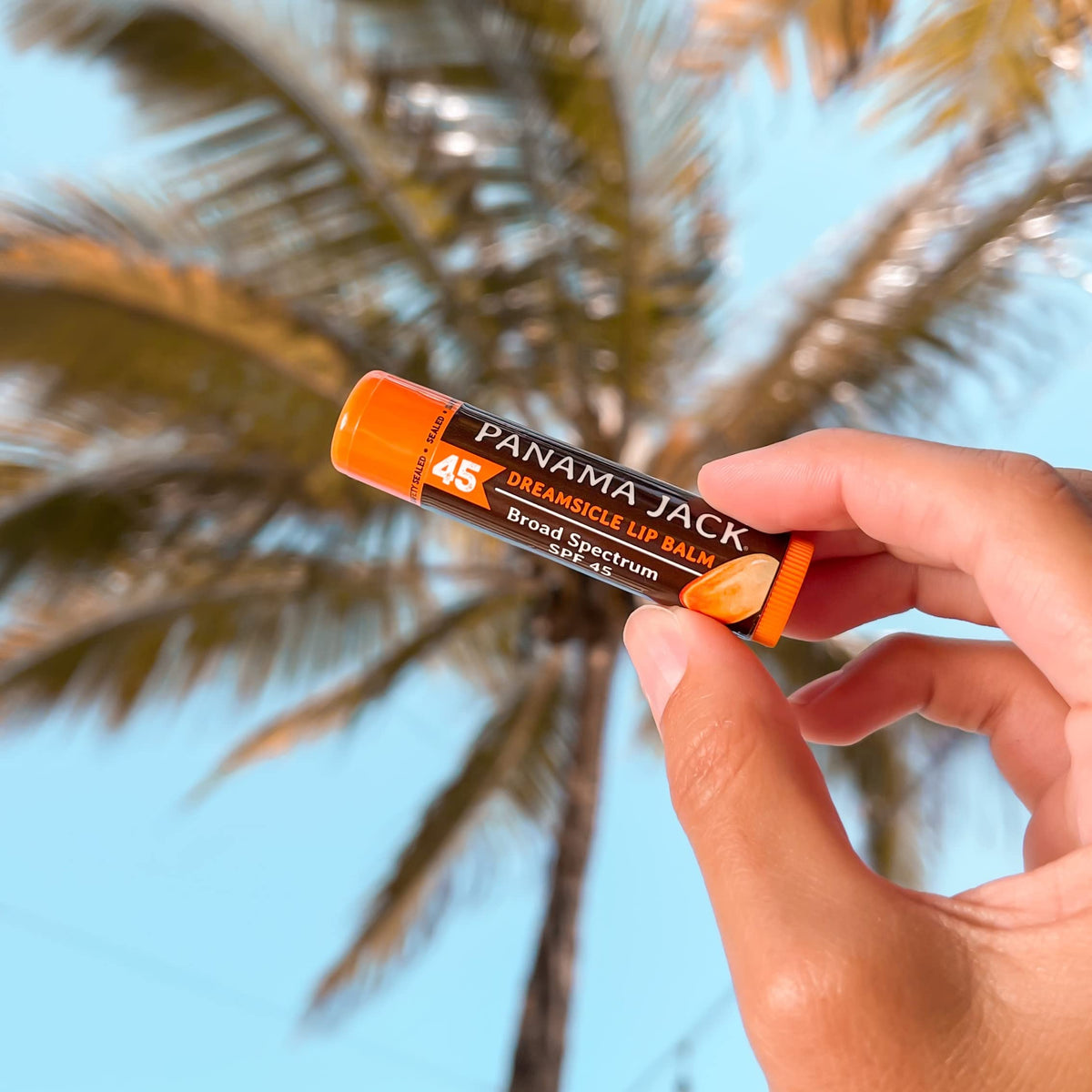 Panama Jack mango tube in hand illustrating pocket-friendly size