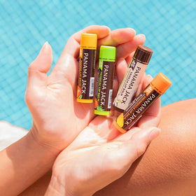 Panama Jack tubes placed beside sunglasses showing travel-ready protection