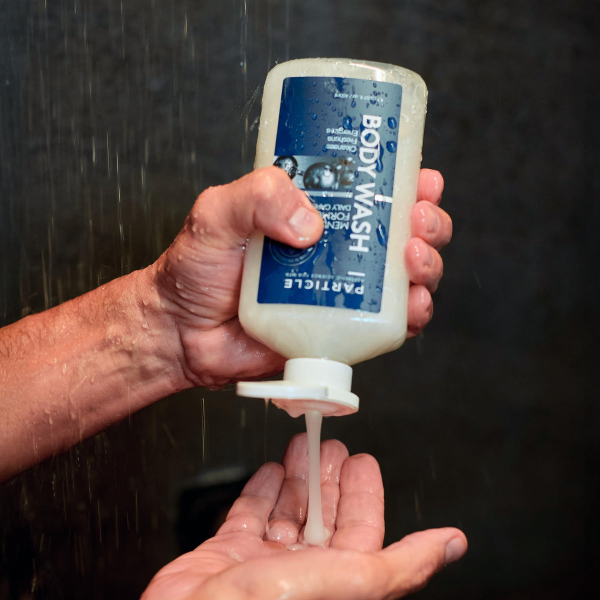 Particle bottle in hand size comparison proving travel and bathroom fit