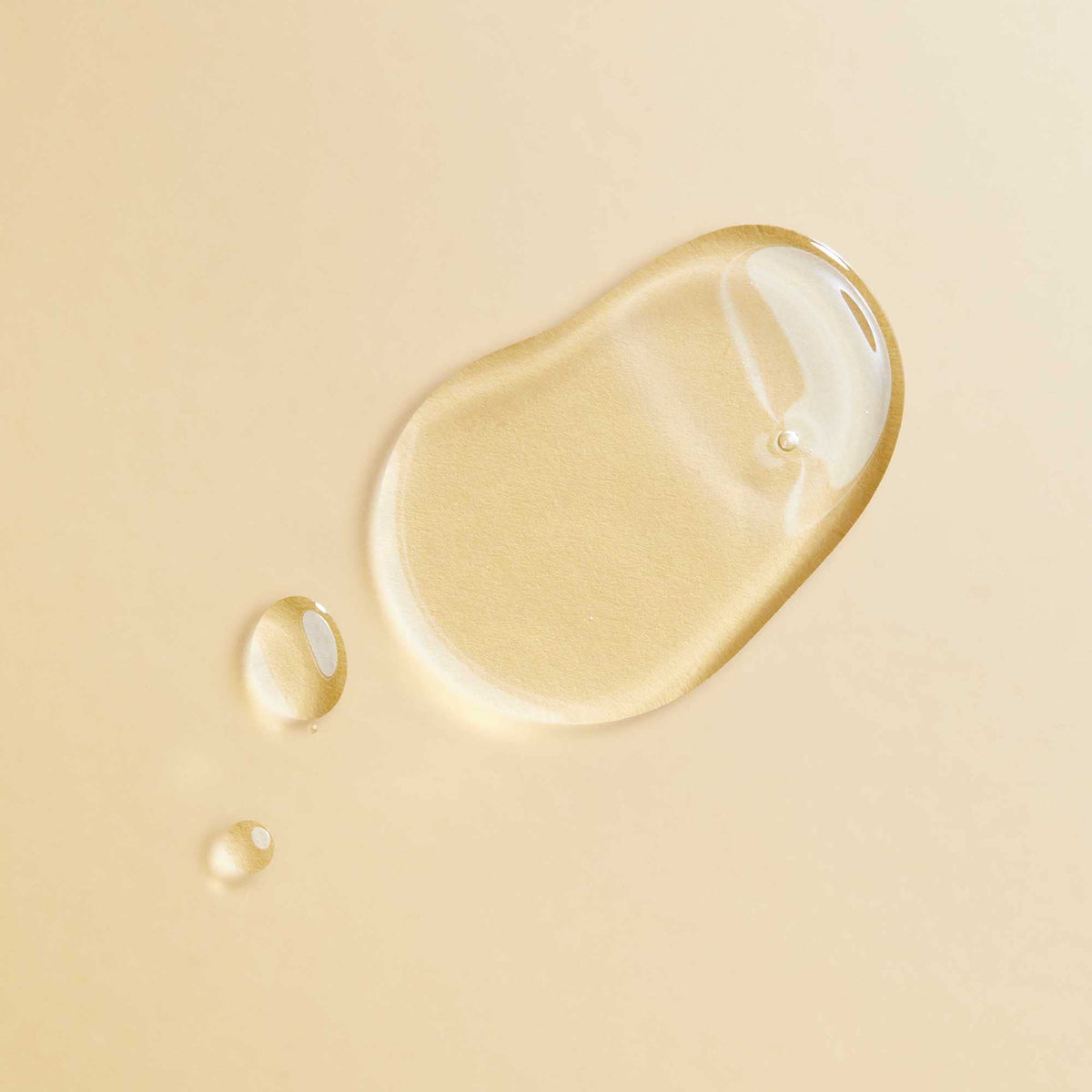 PATTERN single oil drop on finger highlighting lightweight texture for quick absorption and shine