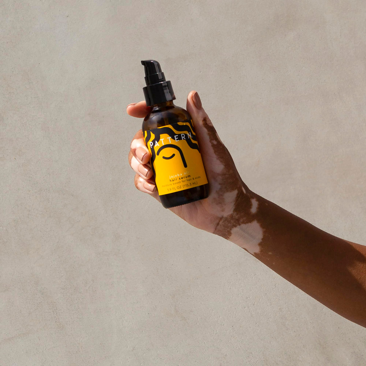PATTERN massaging serum into scalp to help soothe dryness and reduce flaking with gentle circulation