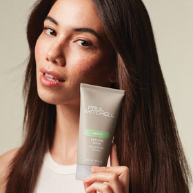 Hand holding Paul Mitchell sealing mask jar to show scale and portability benefit
