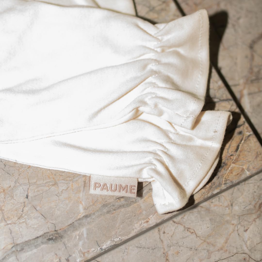 PAUME gloves on nightstand next to moisturizer for nightly routine