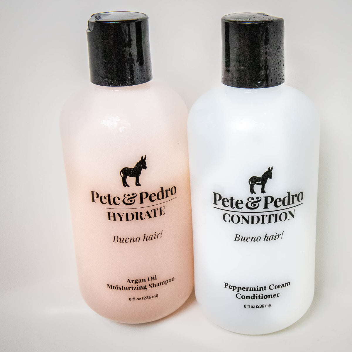 Pete & Pedro bottles in hand to show 8.5 oz size and travel convenience