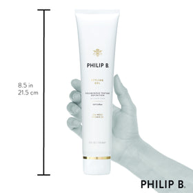 PHILIP B next to a ruler to show the 6 oz size and portability