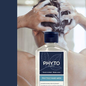 PHYTO bottle beside hand for size comparison showing travel-friendly 8.45 fl.oz.