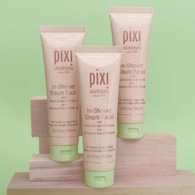 Pixi tube beside a hand for scale to show 135 ml size and travel suitability