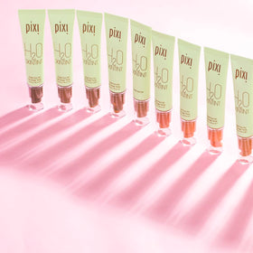 Pixi tube beside a coin showing compact 1.2 fl oz travel-friendly size benefit